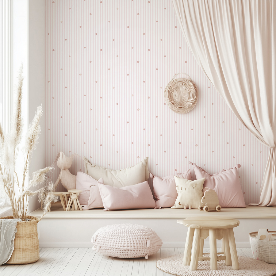 Ett lekrum med en ljus bänk full av kuddar och leksaker, rottingmöbler och tapeten Sophia, med smala ränder och små blomkvistar på krämvit bakgrund i en vintageinspirerad, upprepad design.