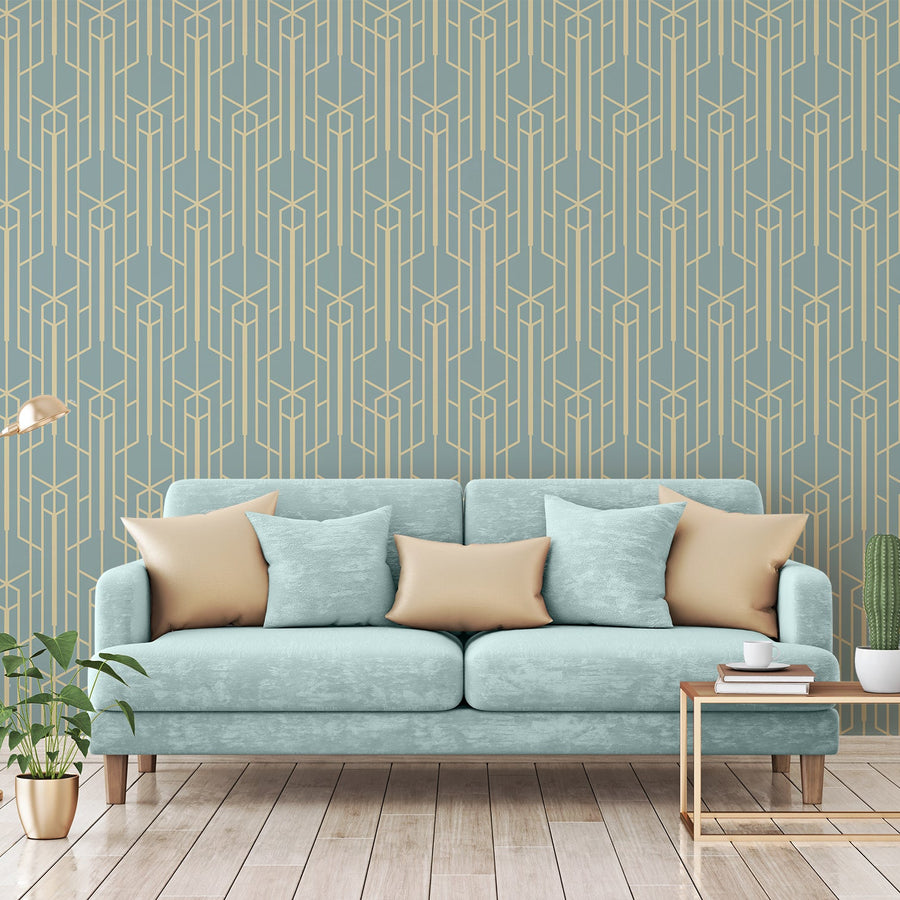 Ett vardagsrum med en ljusblå soffa full av kuddar och tapeten 'Seraphina', en petrolblå tapet med eleganta guldfärgade geometriska linjer i ett vintage art deco-mönster med upprepande solfjäders- och rutmotiv.