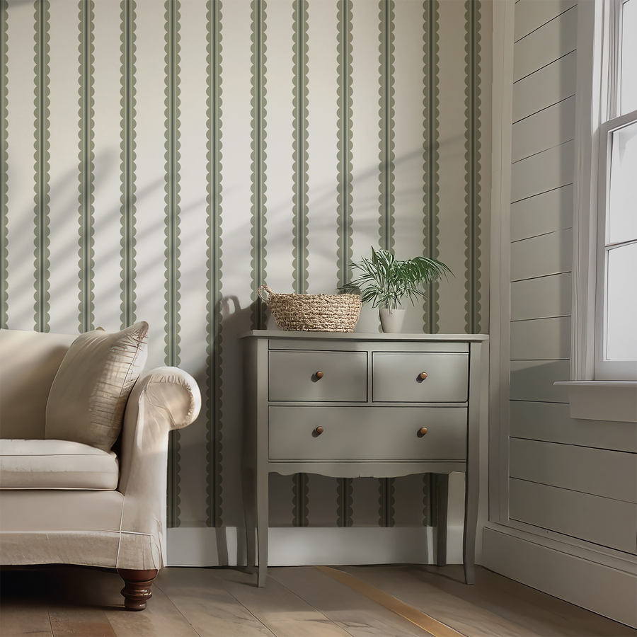 Ett vardagsrum med en beige soffa och en salviagrön sidobyrå samt tapeten Carter, med bågformade ränder med mjukt svängda detaljer i en mjuk neutral färgpalett.