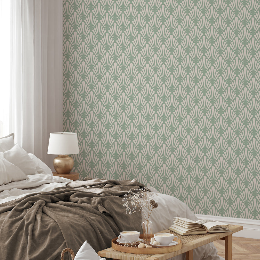 Ett sovrum med sängkläder i naturfärger och Virginia Cambridge, en grön art deco-tapet med stiliserade solfjäderformade blad och geometriska botaniska motiv i ett vintageinspirerat upprepat mönster.